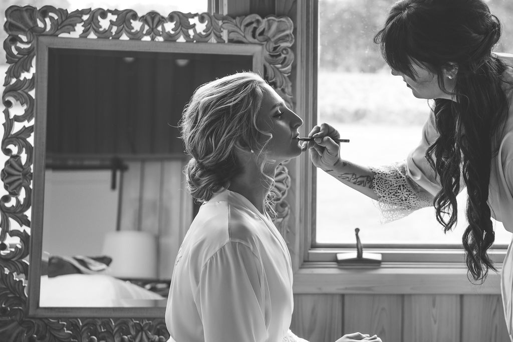 Bride getting her lipstick applied in her getting ready space | choosing a getting ready space on your wedding day