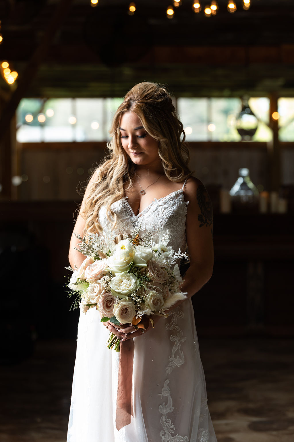 Bride looks down at her beautiful wedding bouquet in the getting ready space | choosing a getting ready space on your wedding day