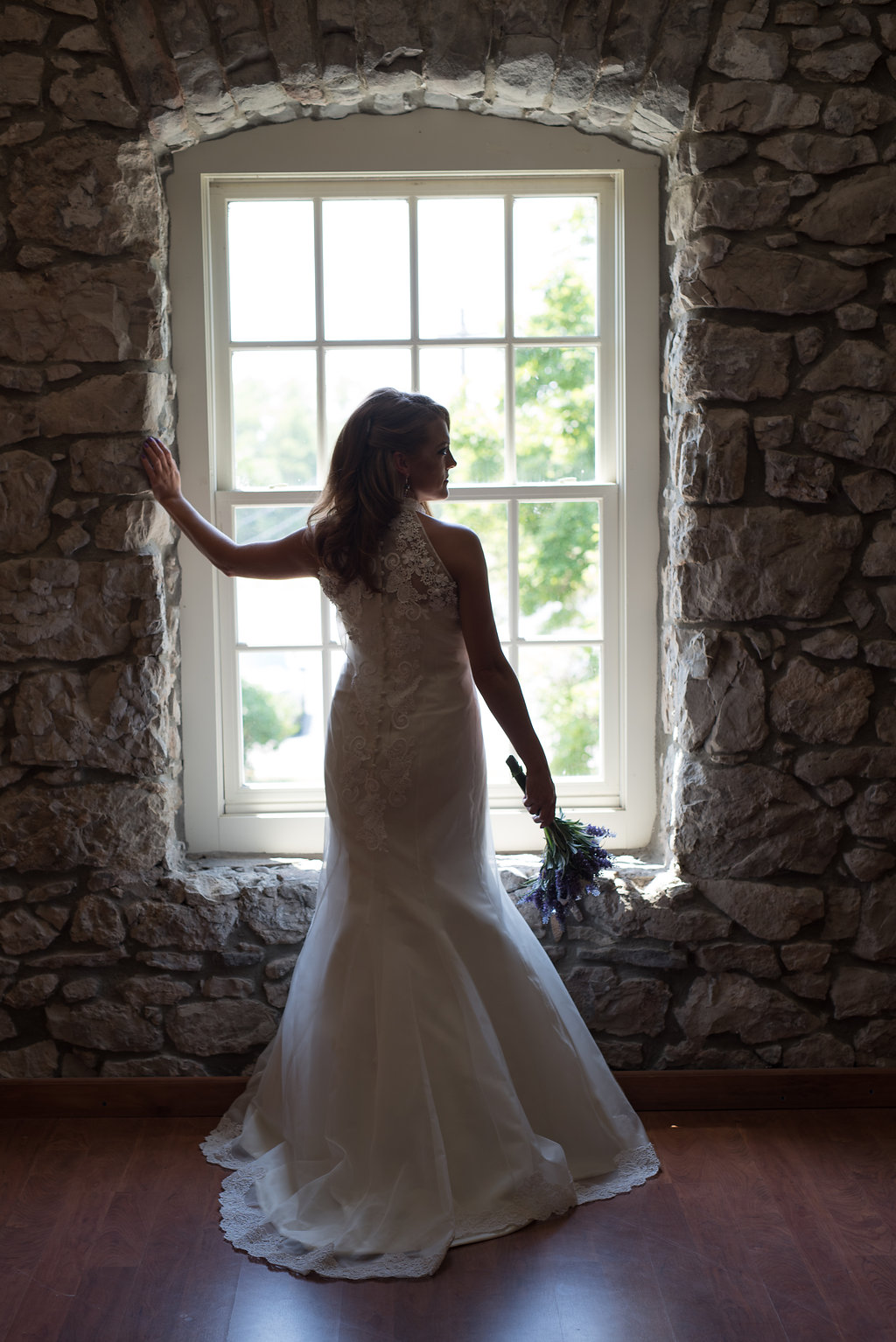 bride looking out window of getting ready space | tips for choosing a getting ready space