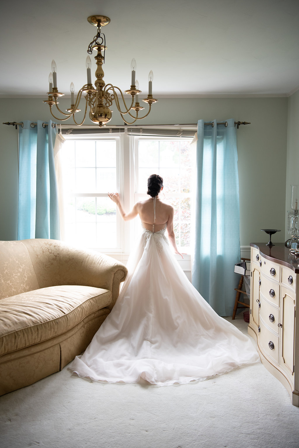 Bride looking out window of bright and airy bridal suite | tips for choosing a getting ready space