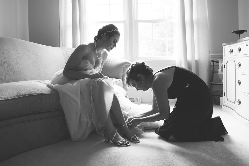 Mother of the bride putting on bride's shoes | how to choose a getting ready space 