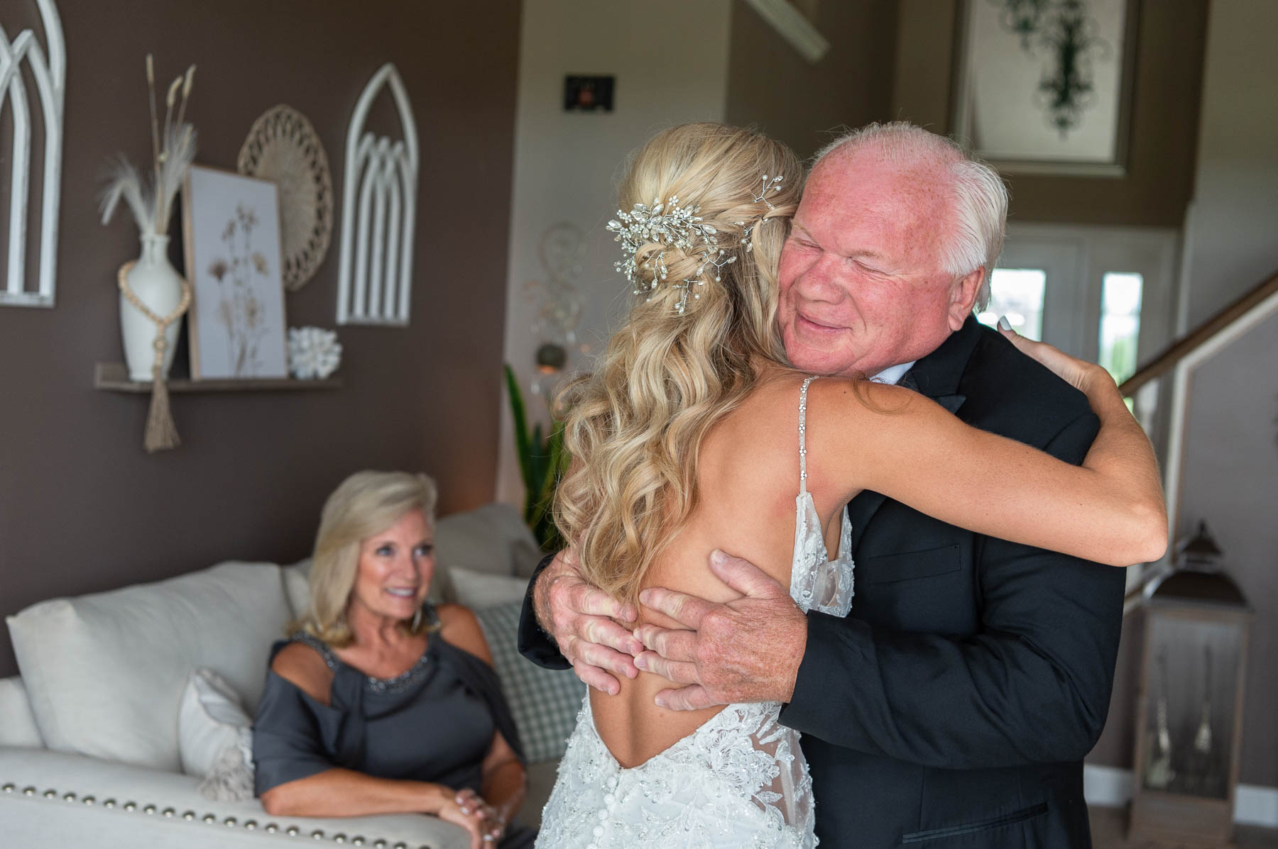 Bride and father hugging with mom looking on