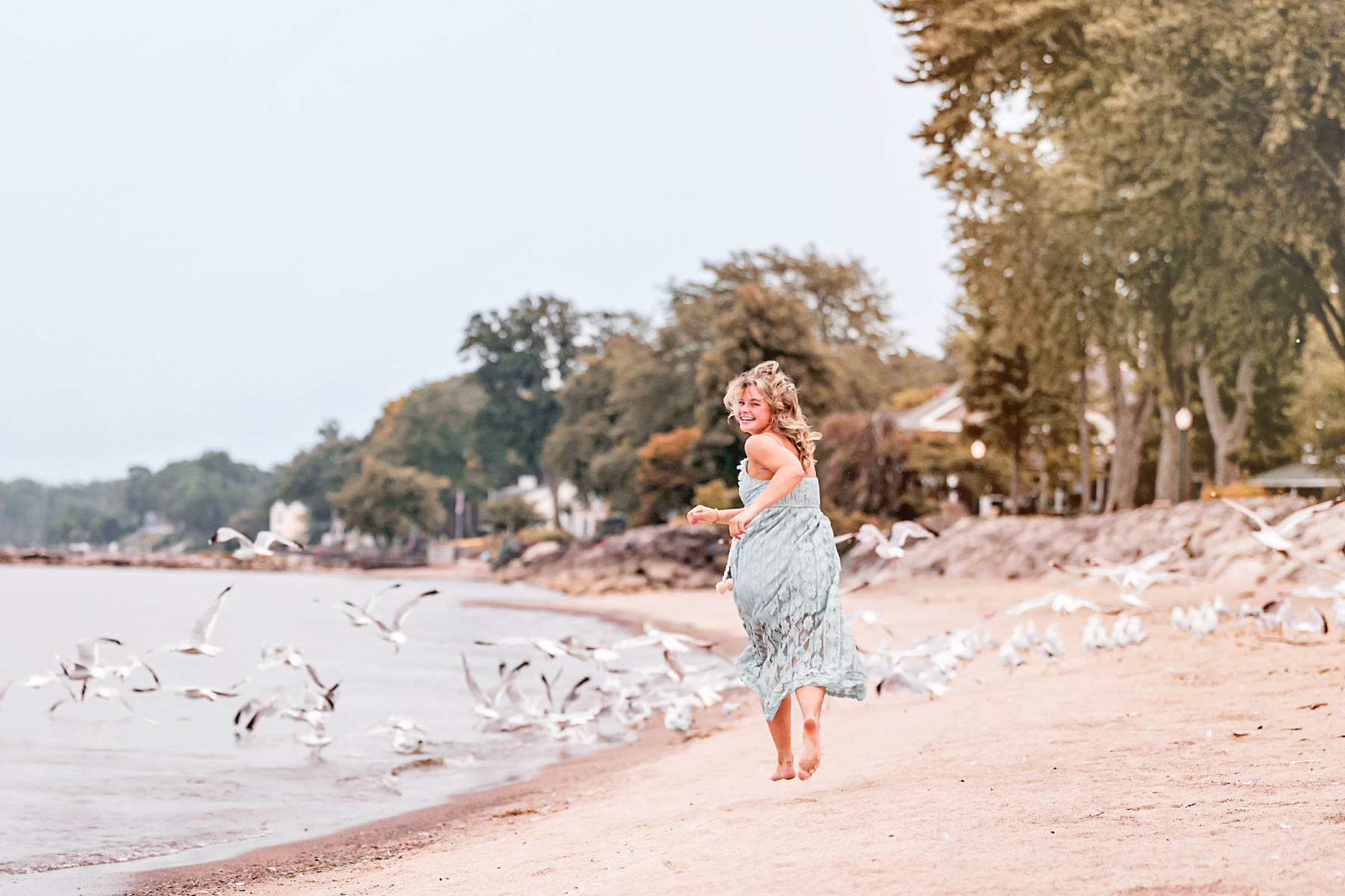 Girl running through a flock of seagulls