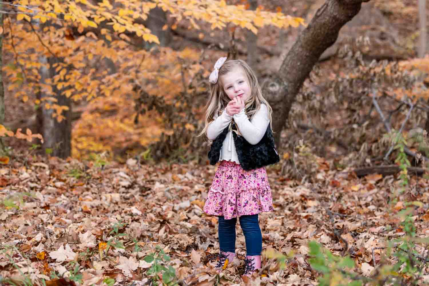 Little girl in fall leaves