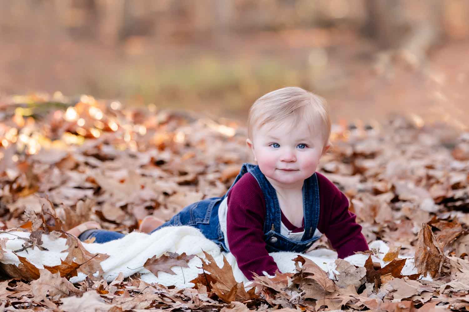 Baby boy in fall leaves