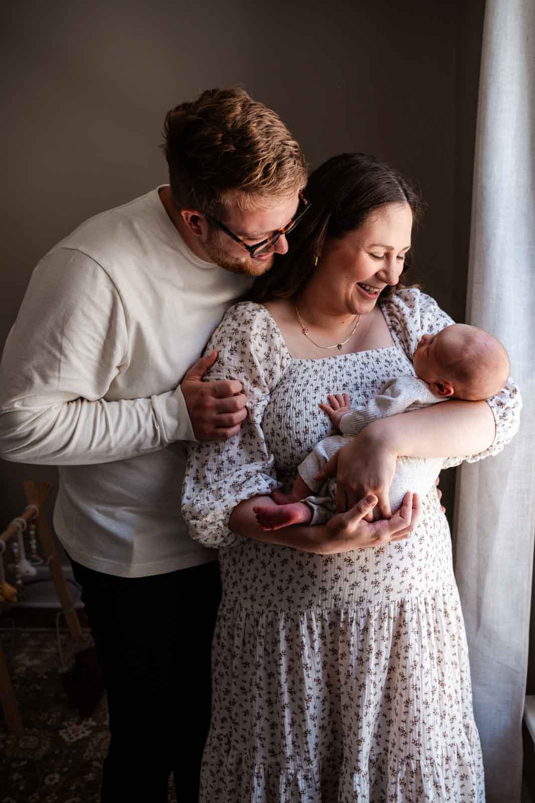 Newborn baby with parents smiling